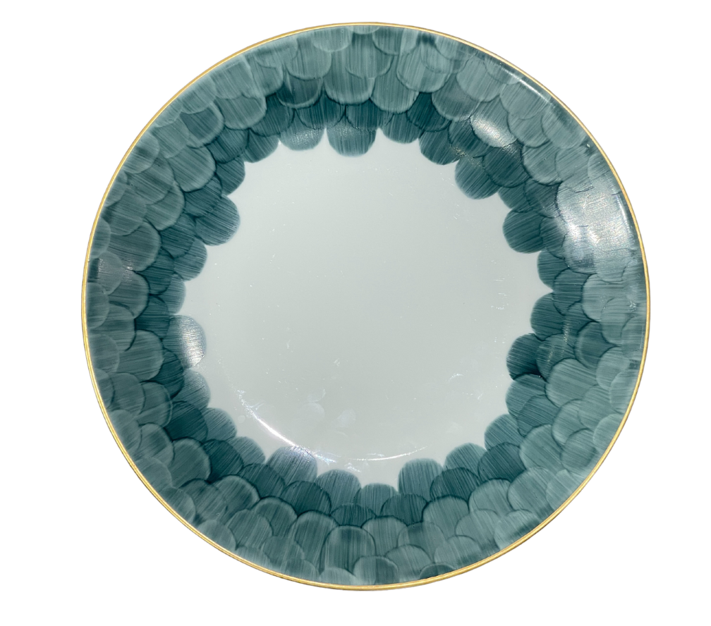 The Marie Daâge Cercle D'Ecailles Gold Filet plate by Marie Daâge features a gold rim and blue-green scalloped edge on white ceramic, offering an elegant, hand-painted design inspired by classic French tableware.