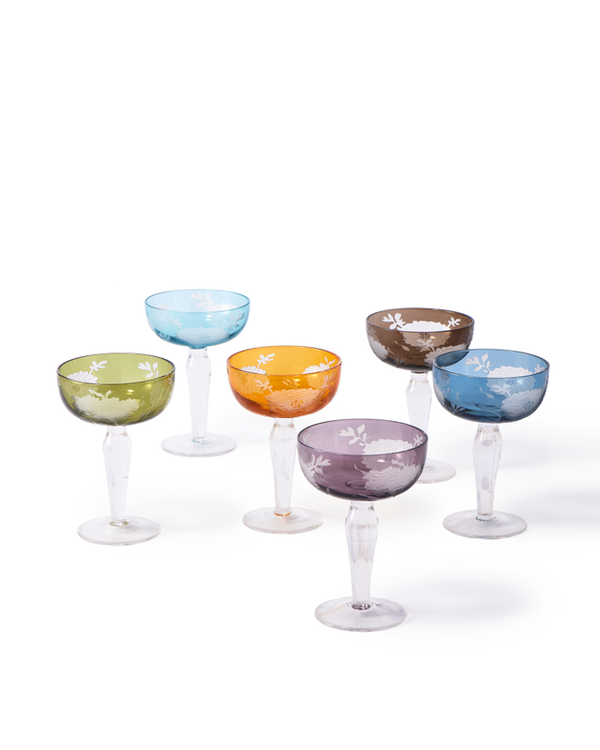 Six Polspotten Peony Coupe Glasses from the Mutli Set of 6, featuring sandblasted and etched floral designs in green, blue, yellow, orange, purple, and brown, are arranged in two rows on a white background.