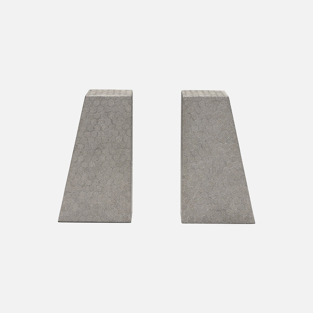 The Rene Faux Shagreen Bookends by Made Goods feature two concrete wedges with architectural edges and textured surfaces, standing upright side by side on a plain light gray background.