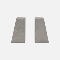 The Rene Faux Shagreen Bookends by Made Goods feature two concrete wedges with architectural edges and textured surfaces, standing upright side by side on a plain light gray background.