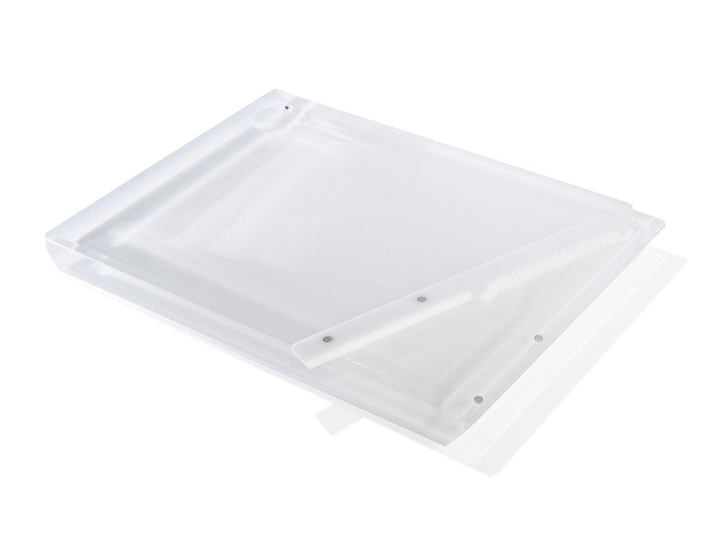 The Apeloig Solid Acrylic Challah Board & Knife features a translucent white rectangular acrylic board with a matching slotted divider, arranged diagonally for a sleek, modern look against a plain white background.