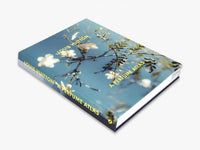 Louis Vuitton: A Perfume Atlas by W.W. Norton Company is a hardcover book with white flowers against a blue sky on the cover. The yellow-titled spine and cover explore fragrance ingredients and the artistry of perfumery.