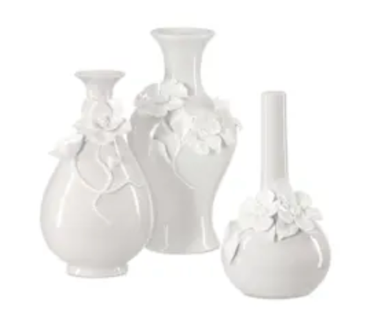 The Angelic Vase White - Set of 3 Assorted by Currey & Company includes three hand-thrown white ceramic vases of different heights, each adorned with delicate raised porcelain flowers and displayed together against a simple white background.