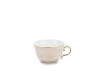 The Ginori 1735 Oriente Italiano Beige Meringa teacup features a gold rim and handle with white floral patterns, showcased against a plain white background—an elegant piece of porcelain dinnerware.