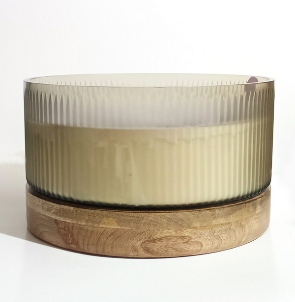 The Luna Fluted Glass Candle w/ Wood Base 12" D by Sagebrook Home features cream wax in a smoky, fluted glass on a round wood base—ideal for displaying the Wood Sage & Sea Salt scent against a white background.