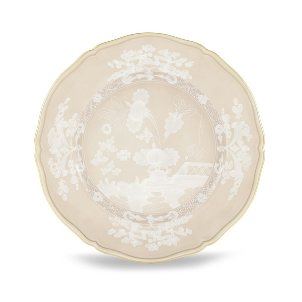 The Oriente Italiano Beige Meringa plate by Ginori 1735 is a round porcelain dinnerware piece featuring a beige background, white floral motifs, scalloped edge, and a thin gold rim.