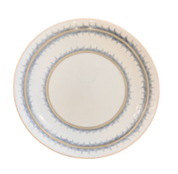 The Marie Daâge Marie Daage Rafia Stripes plate is a round white ceramic piece with a blue and gold patterned rim, reflecting the elegance of hand-painted Limoges porcelain tableware, shown against a white background.