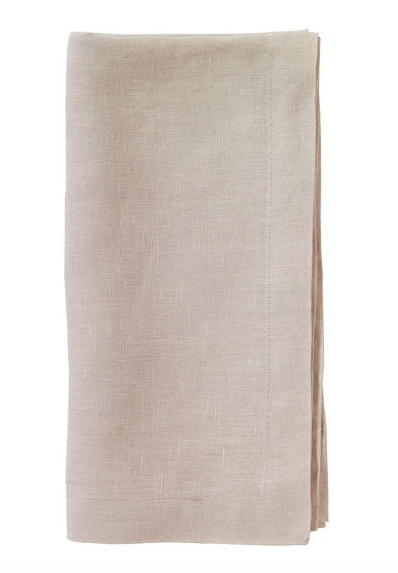 The Bodrum Riviera Napkin Set of 4 features neatly folded, light beige stone-washed linen napkins with visible edge stitching, displayed on a white background for an elegant everyday touch.