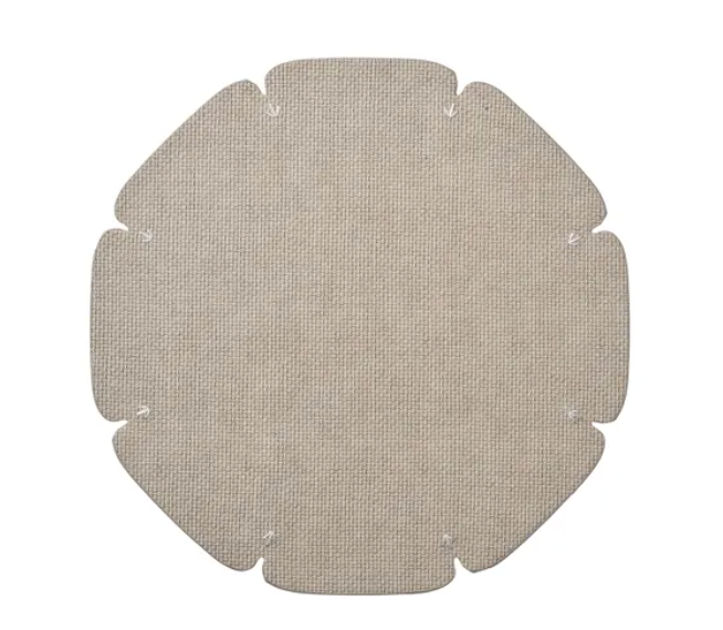 A grey, textured, octagonal fabric piece with rounded corners and small notches along the edges, this contemporary placemat—part of the Divot Placemat Set of 4 by Kim Seybert—is displayed flat against a white background and makes a versatile addition to any collection of dining room accessories.