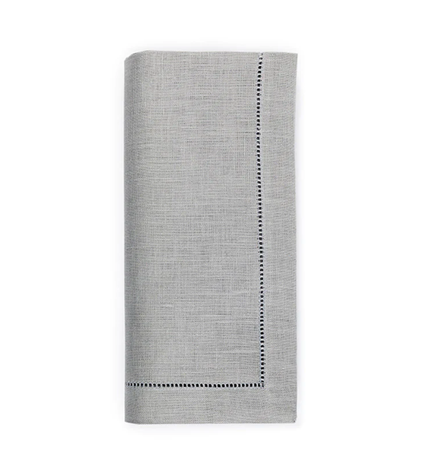 The Sferra Festival Napkin Set of 4 features neatly folded light gray European linen napkins with a decorative stitched border on two edges, shown against a white background.