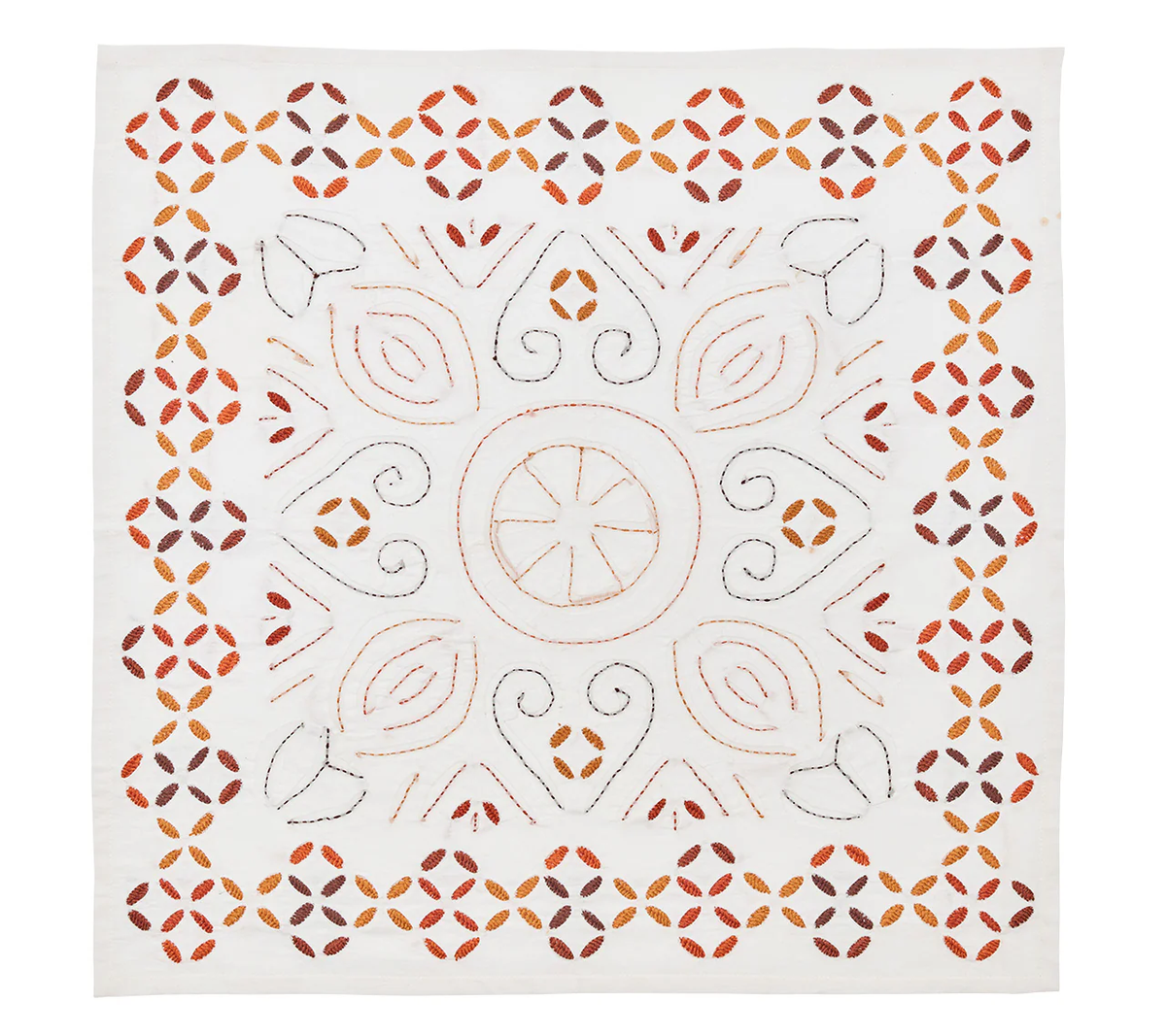 The Kim Seybert Malta Embroidered Napkin Set of 4 features white handcrafted napkins with orange, brown, and black symmetrical floral and geometric embroidery in a central circular motif.