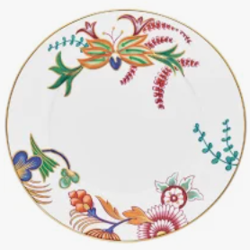 The Raynaud Imari Dinnerware is a white ceramic plate with a gold rim, featuring vibrant red, green, blue, and orange floral and leaf designs inspired by Japanese art.
