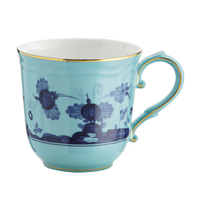 A porcelain mug by Ginori 1735 from the Oriente Italiano Dinnerware Iris collection, featuring turquoise glaze, gold-rimmed edge and handle, and dark blue chinoiserie floral motifs.