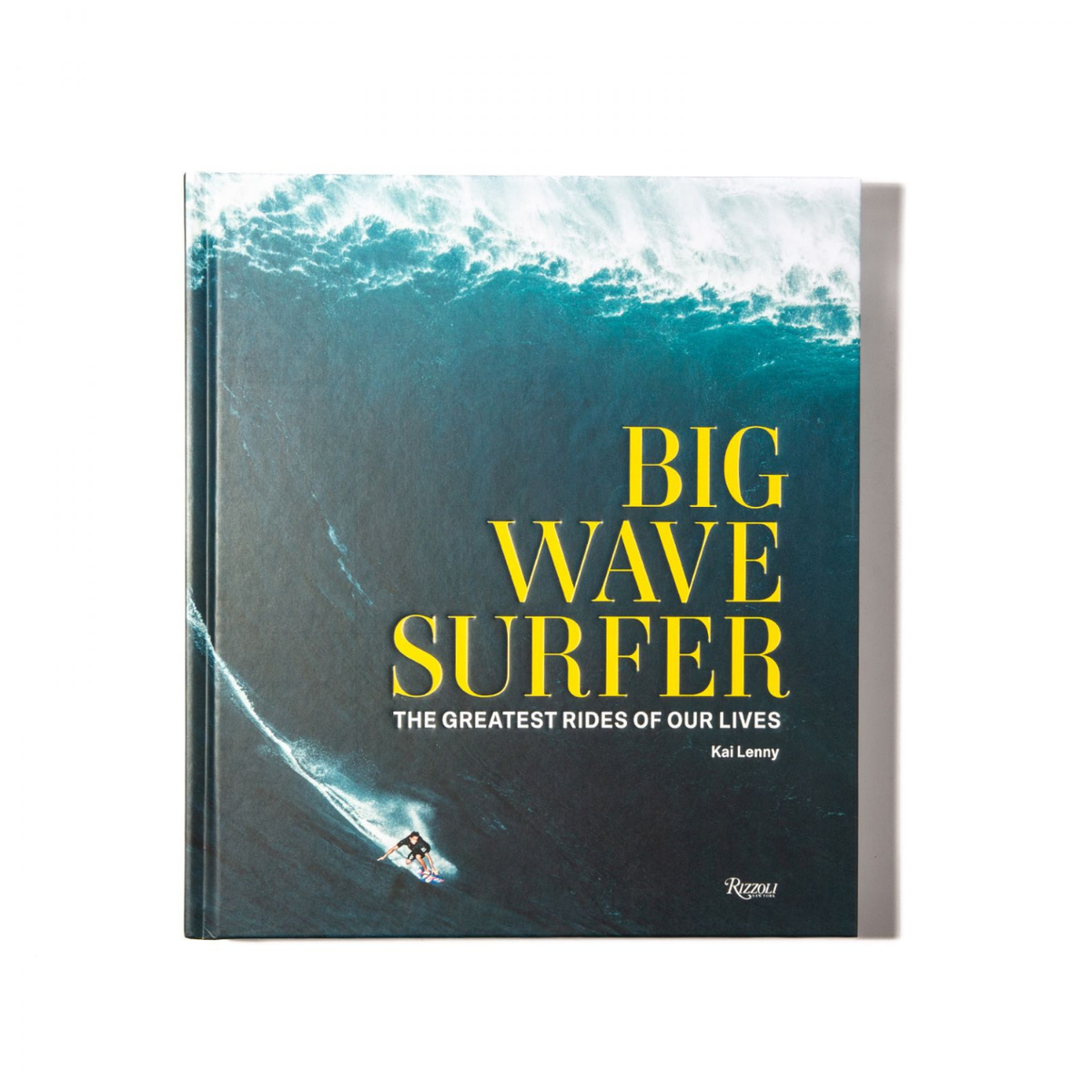 The book "Big Wave Surfer" by Rizzoli features a surfer riding a huge wave, bold yellow title text, and dramatic surfing photography that captures the excitement of big wave surfing.