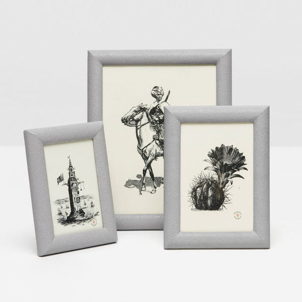 Three Pigeon and Poodle Oxford Faux Shagreen Frames in Ash Gray elegantly display art of a lighthouse, a horseback rider, and a cactus.