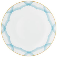 The Aura Dinnerware by Raynaud features a white ceramic plate with a thin gold rim and an interlocking blue border, offering a contemporary design with a plain center that suits any setting.