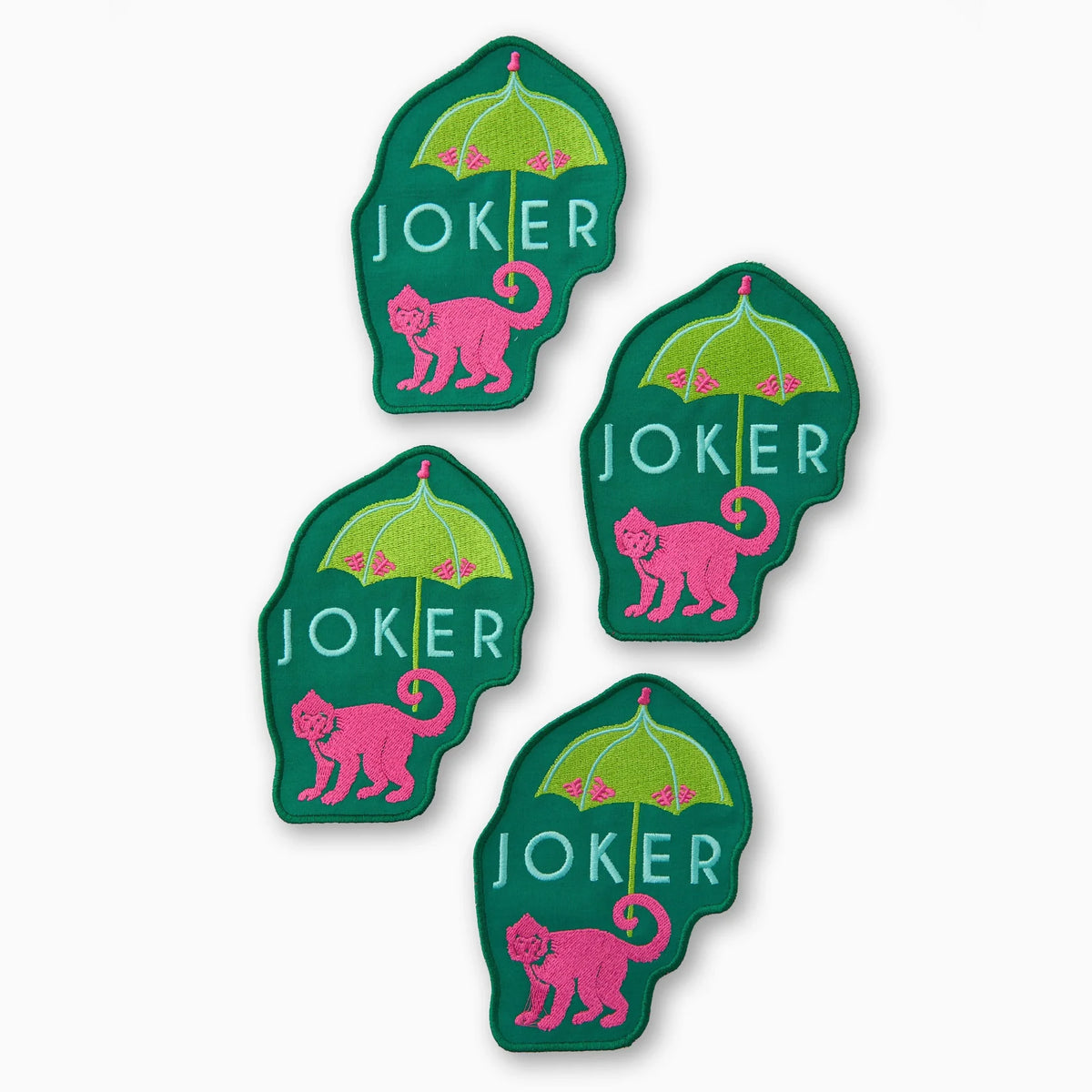 The Oh My Mahjong Money Joker Cocktail Napkin Set includes four green napkins, each with a pink monkey under a lime umbrella and "JOKER" text—fun, unique linen accessories for your bar cart or cocktail parties.