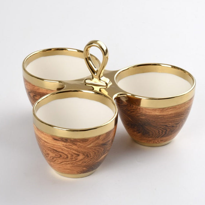 The PAMPA BAY Madera 3 Part Server features three small round cups with a wood grain pattern and gold rims, connected by a gold handle in a triangular arrangement.