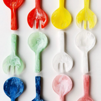 A grid of Nashi Home Swirl Colored Resin Jumbo Servers—each row featuring a spoon and fork in vibrant red, yellow, green, white, blue, and pink swirling patterns.