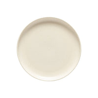 A round, off-white ceramic plate from the Costa Nova Pacifica Vanilla Dinnerware collection with a smooth surface, shown from above on a white background.