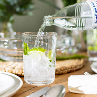 The Walden Glassware Set/4 by Simon Pearce is perfect for everyday use—enjoy a refreshing mix of ice, lime, mint, and sparkling water served in these elegant glasses on your dining table.
