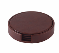 The Bodrum Tanner Coaster Set & Holder features a round brown leather holder with an open front slot, neatly stacking elegant coasters for easy access and protection of your furniture.