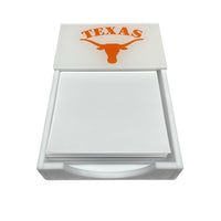 The Eye Candy College Note Pad is a white holder with blank paper, featuring an orange Texas Longhorn logo and "TEXAS" on the lid—an ideal graduation gift.