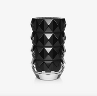 The Baccarat Louxor Round Vase Black features a glossy black geometric diamond pattern with a clear base, resembling a faceted crystal, displayed against a plain white background.