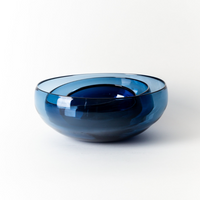 The Gary Bodker Nesting Bowls Midnight features a deep blue, hand-blown bowl with smooth, rounded edges and a glossy finish, highlighting handcrafted elegance against a plain white background.
