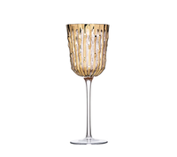 The Bamboo Glassware Gold Set of 4 by Kim Seybert features tall, elegant wine glasses with long clear stems and textured amber bowls with vertical ridges, crafted from mouth-blown glassware.