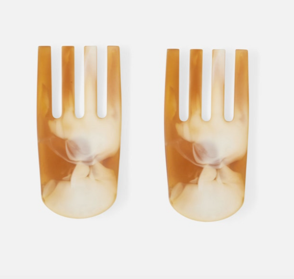 The Parker 2-piece Serving Set - Amber by Blue Pheasant features wide, marbled tan and cream salad servers with three prongs each, crafted from glossy, translucent material and shown side by side on a white background.