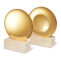 The Aerin Constantin Bookend Set of 2 features round, gold-finished discs atop rectangular marble bases. These contemporary brass bookends have a polished shine and sleek mid-century design perfect for any modern space.