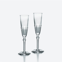 The Baccarat Harcourt Eve Flutes Set of 2 features elegant champagne glasses with hexagonal bases, shown side by side on a plain, light backdrop.