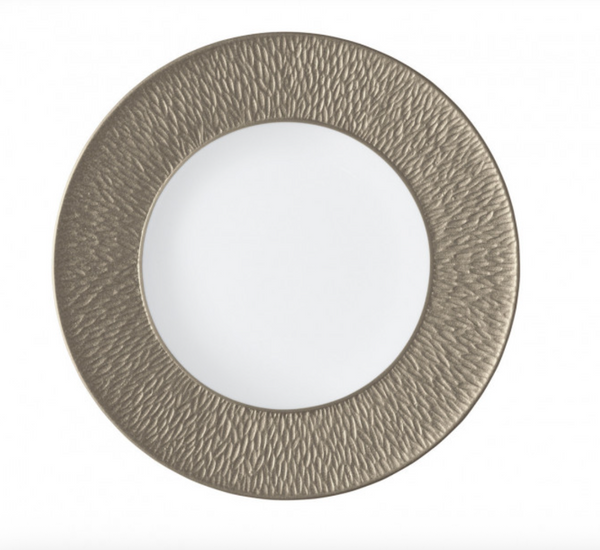 The Raynaud Mineral Irise Salad/Dessert Plate in Greige features a round white center with a wide, textured metallic gold rim, shown on a plain white background.