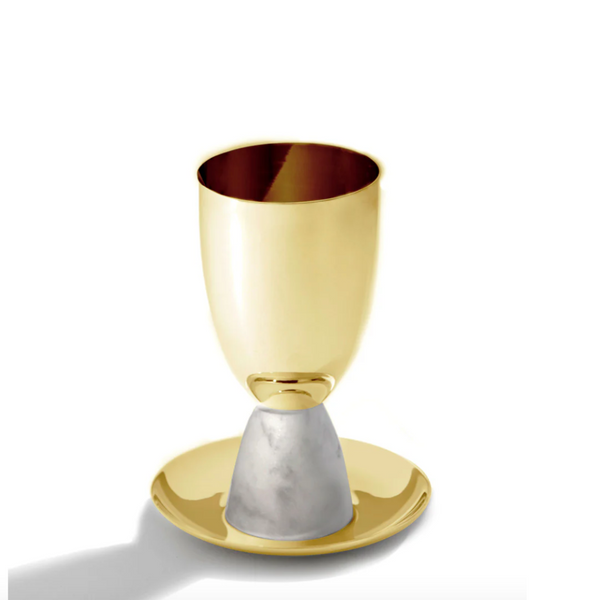 The Coluna Marble Kiddush Cup Gold by Anna New York features an Italian Carrara Marble stem and rests on a matching gold saucer, beautifully highlighted against a white background—ideal for Shabbat celebrations.