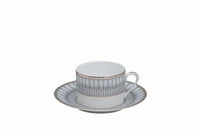 A white Arcades Platinum teacup with handle and matching saucer feature silver and gold geometric edges. Made in France by Philippe Deshoulieres BIA, set against a plain white background.