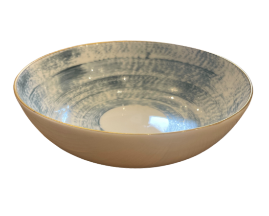 The Marie Daâge Agate Dinnerware features a shallow ceramic bowl with a smooth beige exterior and a blue, textured circular interior, evoking luxury tableware. Product by Marie Daâge, set against a white background.