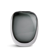 The Paul Vase by FlowDecor Inc. features a modern oval shape in smokey grey glass with a silver rim, bringing sophisticated style to any home décor, especially when displayed against a white backdrop.