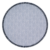 A round, light blue Bodrum Whipstich Round Placemat with a dark blue whipstitch edge.