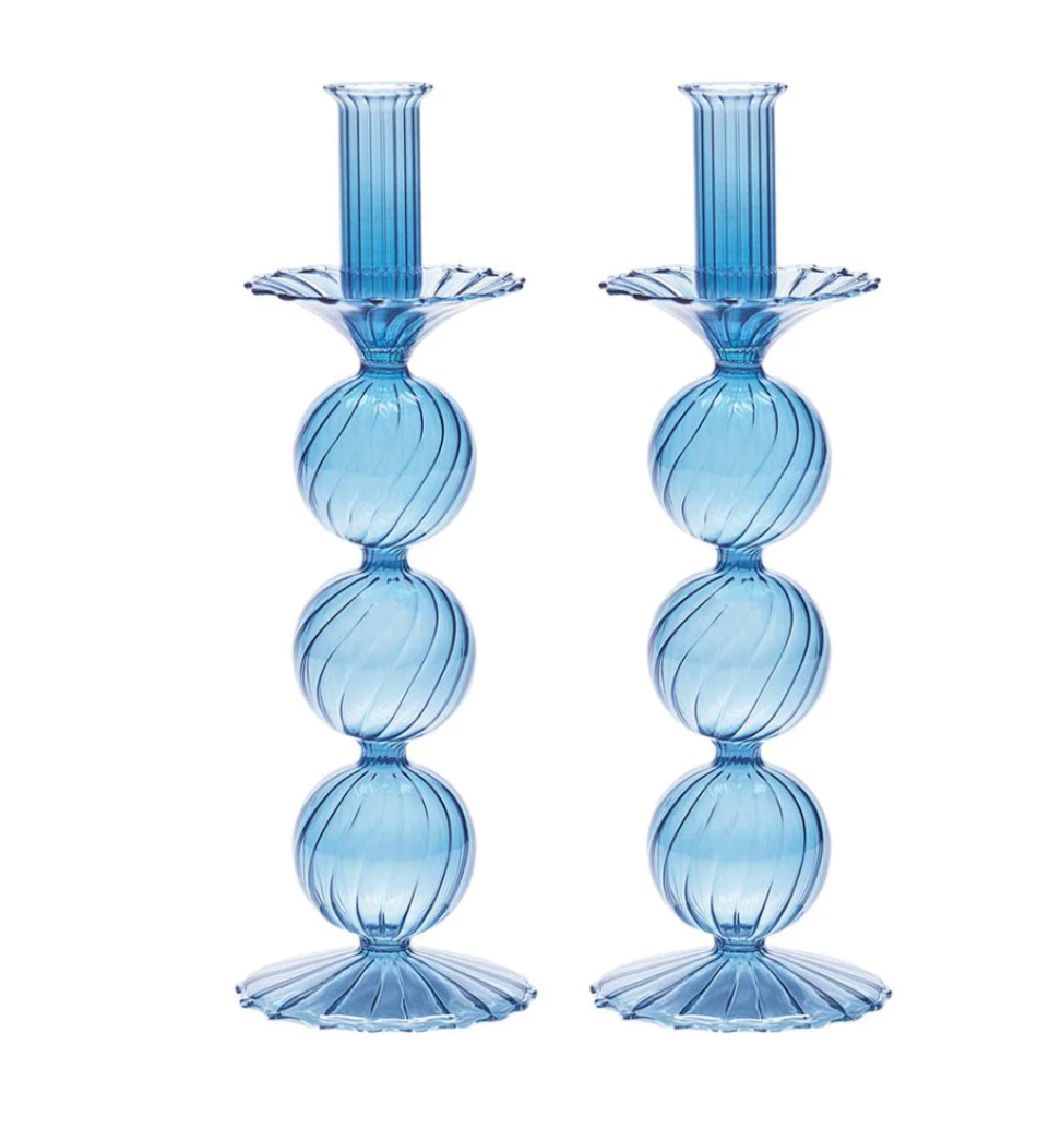 The Iris Candlestick Holder Set of 2 by Kim Seybert features blue hand-blown glass with three stacked, ribbed spheres forming the stem, and fluted bases and tops, standing side by side.