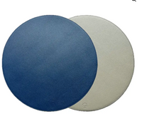 Two overlapping Reversible Placemats from Von Gern Home, one blue and one light gray, add elegance to a white table setting.
