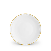 Neptune Gold by L’Objet is a white fine porcelain plate featuring a 24k gold rim and a debossed wave pattern, showcasing the brand’s signature elegance.