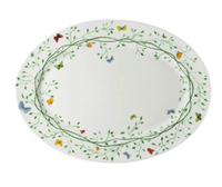 The Raynaud Histoire Naturelle Dinnerware features an oval white plate with a green vine border and colorful butterfly motifs—red, orange, yellow, green, and blue—showcasing French excellence at your table.