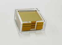A Tizo Acrylic Coaster Set Metallic features stylish coasters neatly stacked in a clear holder, displayed against a plain white background.
