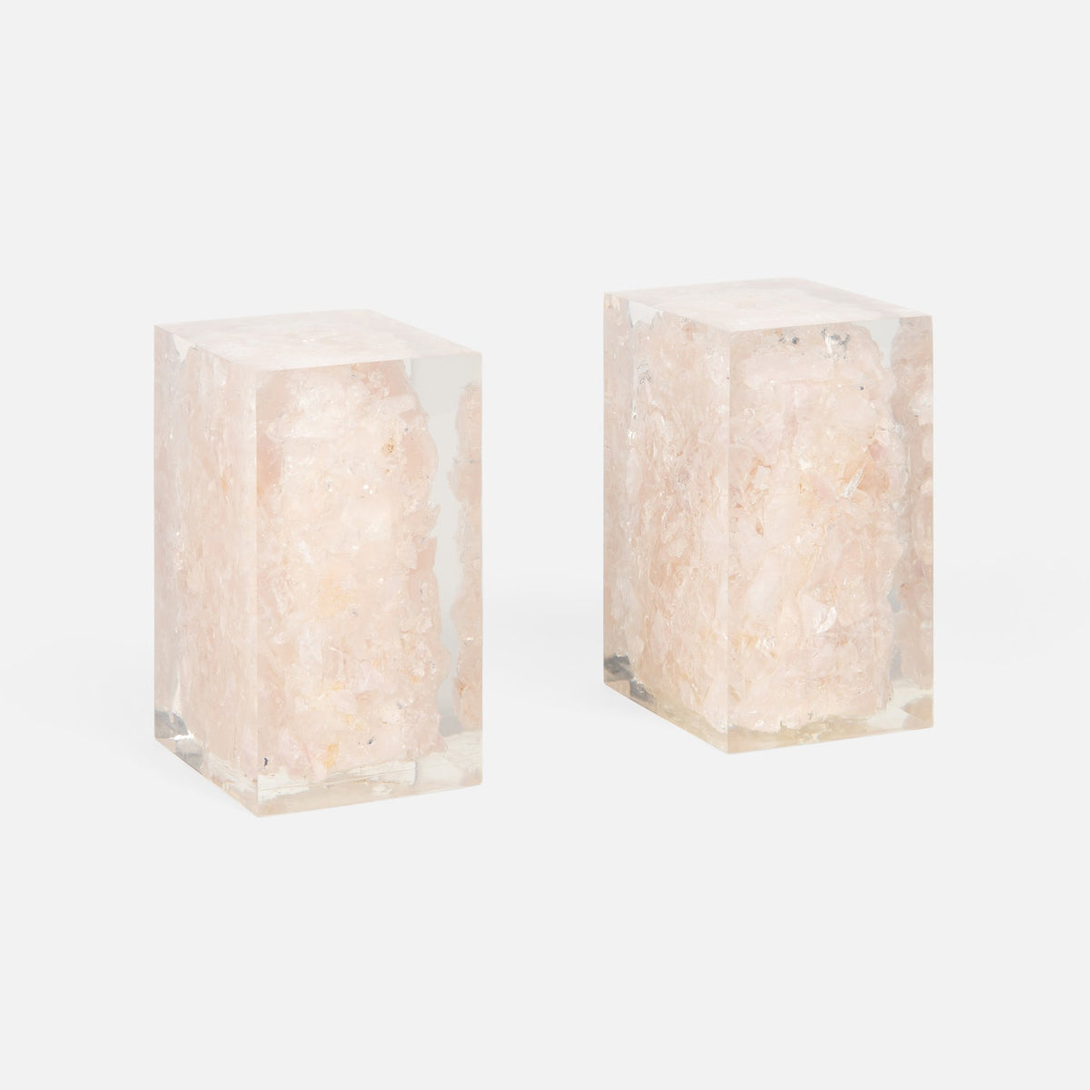 The Jessie Bookends Set by Made Goods features rectangular clear resin bookends filled with pink crystal clusters—a sparkling decorative accent for any shelf.