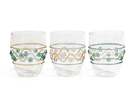 The Zodax Festa Tumbler Set includes three clear glass tumblers in green, amber, and pink tones, featuring decorative wavy lines and raised bead accents, displayed side by side against a white background.