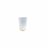 The Dynasty Cups Cotton by Gary Bodker is a hand-blown glass piece filled with cloudy white liquid, showcased on a plain white background to emphasize its minimalist design.