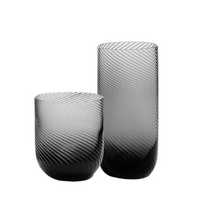 The Richard Brendon Optic Glassware Smoke Set of 2 features one short, round vase and one tall, cylindrical vase, both with a black gradient and diagonal ribbed texture, displayed against a white background.