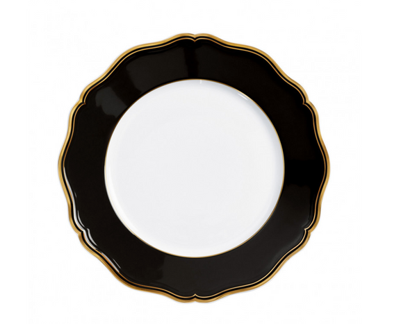 The Raynaud Mazurka Dinnerware Or Black plate features a round, white design with a wide, scalloped black rim and gold trim—photographed from above on white—perfect for luxury dining and showcasing French craftsmanship.