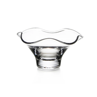 The Simon Pearce Chelsea Bowl features a wide, wavy, flared rim and stands on a round base. This handmade glass bowl is elegantly presented against a white background.